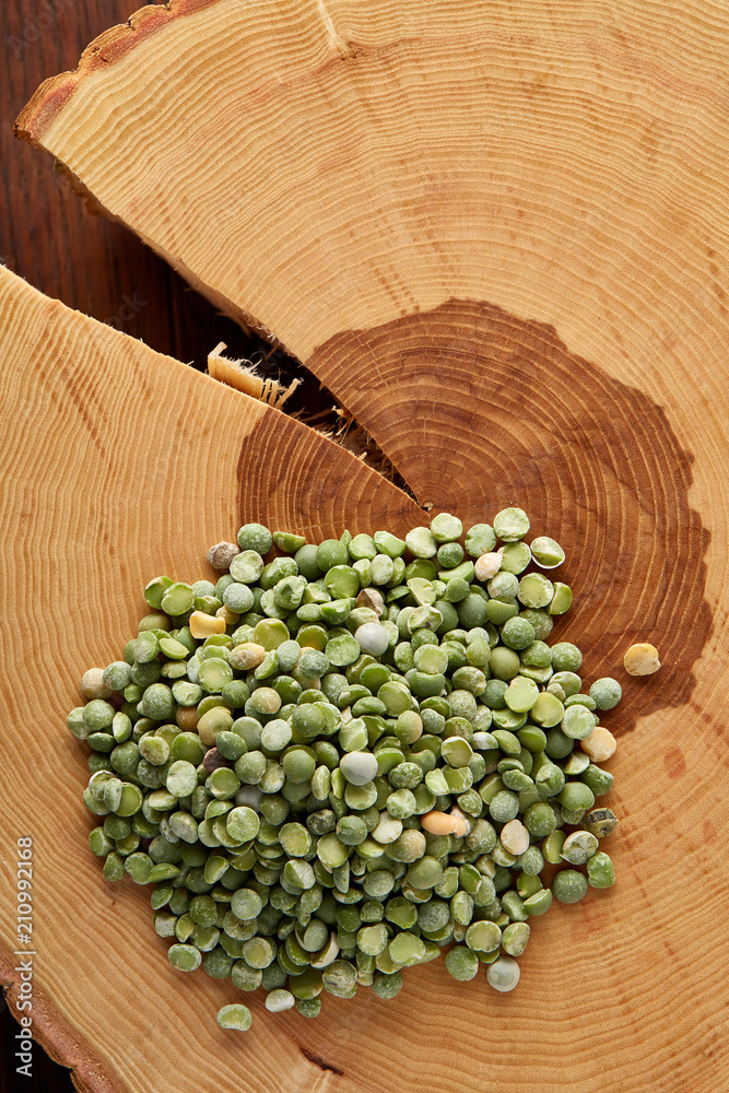 Pile of green peas on a wooden log, close-up, top view, selective focus. Pile of green peas on a wooden log, close-up, top view, selective focus.
