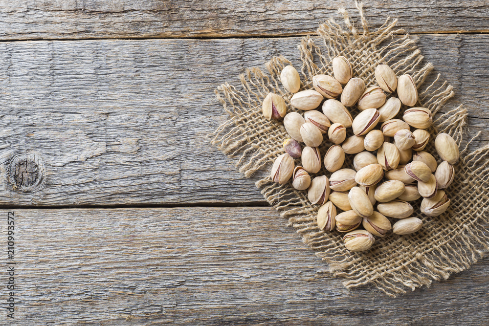 Delicious salted pistachios on wooden background Copy space