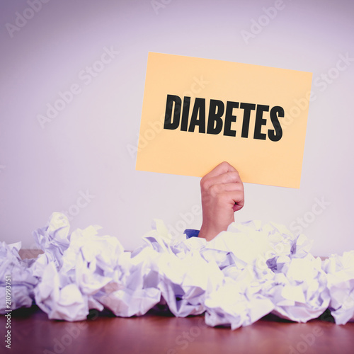 HAND HOLDING YELLOW PAPER WITH DIABETESCONCEPT photo