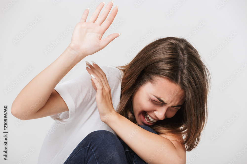 Scared screaming woman raising hands up in defense Scared screaming woman raising hands up in defense