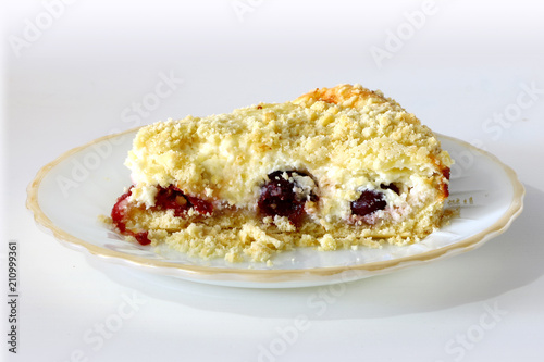 curd cake with crumb and cherries on a plate on a light background
