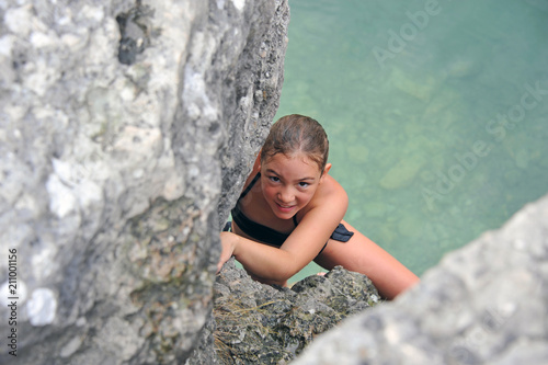 Young girl climbing out of quarry lake. Gotland, Sweden. © Karin