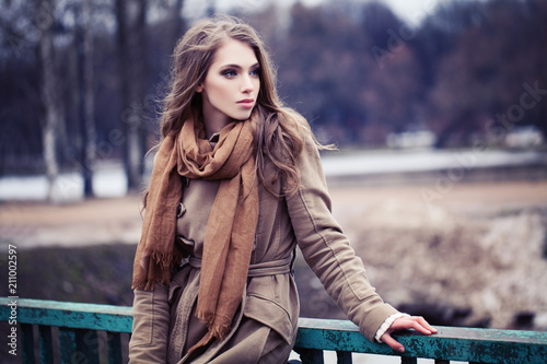 Young woman in brown coat outdoors