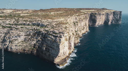 Scenic aerial view of dramatic high precipice with beautiful sea view. Drone top view shot of dangerous stony cliffs. Gozo island, Malta