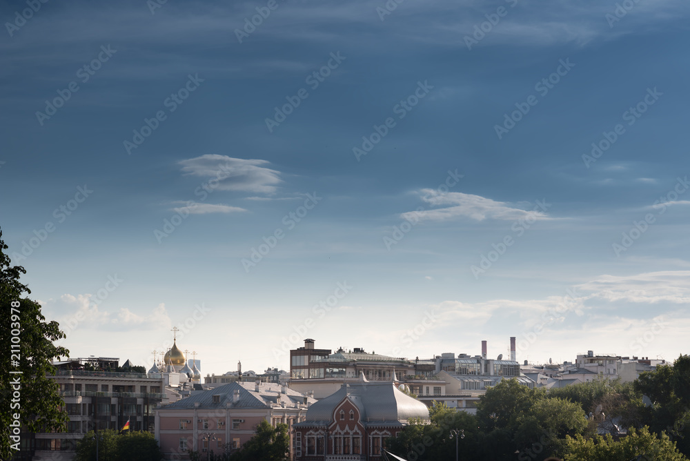 Moscow city historical skyline panorama with roofs and sun.