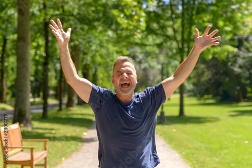 Happy man running in park on sunny day