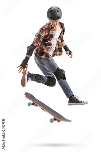 Teenage skater boy with protective equipment jumping