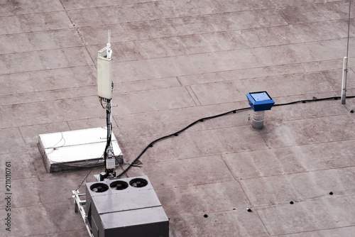 Slika na platnu Roof of a commercial building with a external units of the commercial air conditioning and ventilation systems, cellular antenna and lightning rod