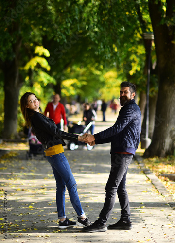 Man and woman with smiling faces on autumn alley background