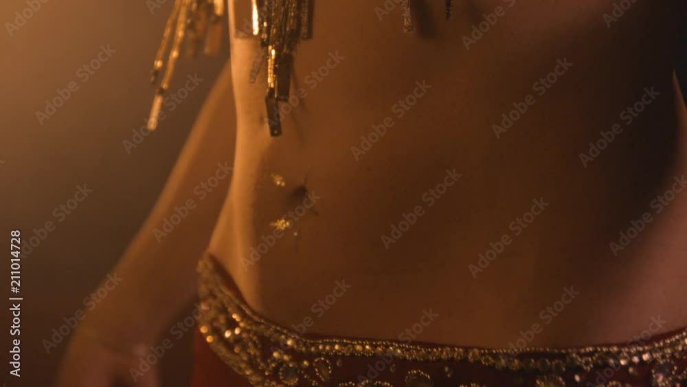 Belly dancer slow motion, warm oriental mood with smoke