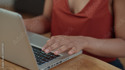 Close up of young Afro American female hands using laptop computer while sitting at table. © therabbithole
