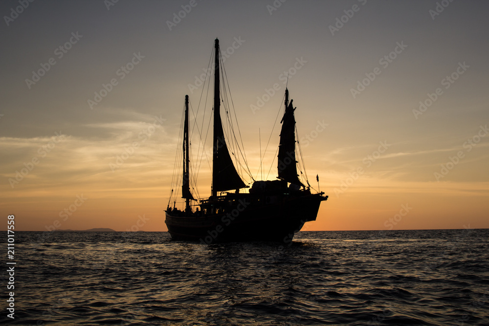 Old junk style sailboat cruising in the sunset in the Andaman sea in Thailand