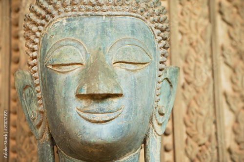 Face of an ancient Buddha statue located outside of the Hor Phra Keo temple (former temple of the Emerald Buddha) in Vientiane, Laos.