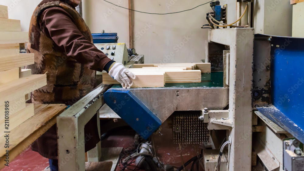 Manual worker doing his job at the woodworking factory. Environm