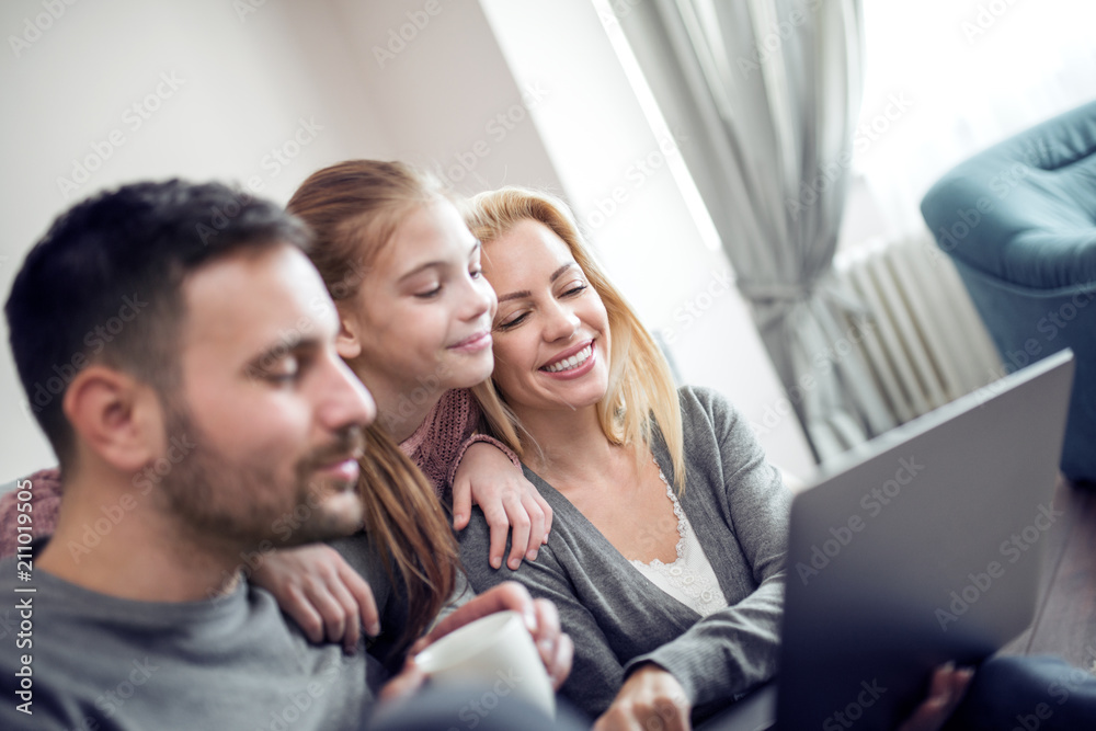 Young family of three using laptop at home Young family of three using laptop at home