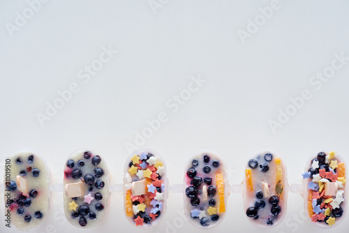 top view of cold homemade ice cream with fruits and berries on grey background