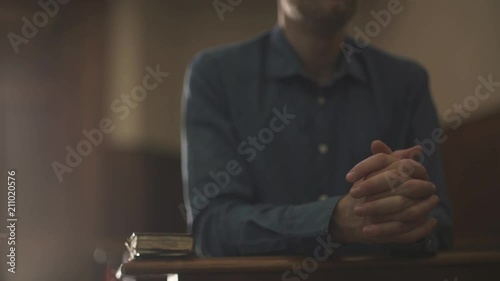 Devote man kneeling in the Church and praying photo