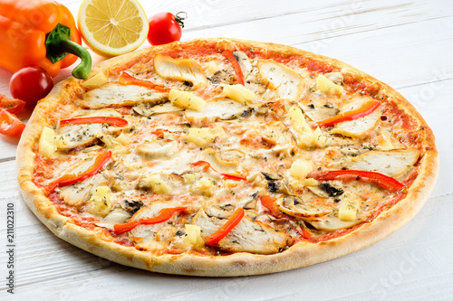 Appetizing hot Italian pizza with meat, pineapple and pepper on 