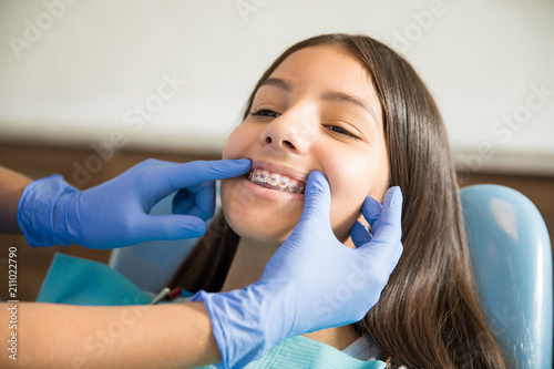 Fototapeta Naklejka Na Ścianę i Meble -  Girl With Braces Being Examined By Dentist In Clinic