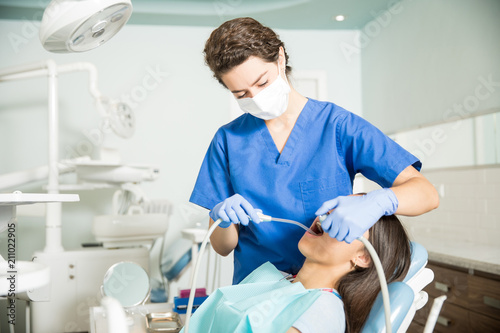 Dentist Using Equipment While Treating Girl In Clinic