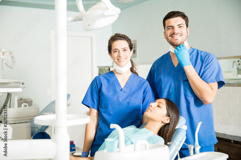 Portrait Of Smiling Dentists Standing By Patient At Clinic Portrait Of Smiling Dentists Standing By Patient At Clinic