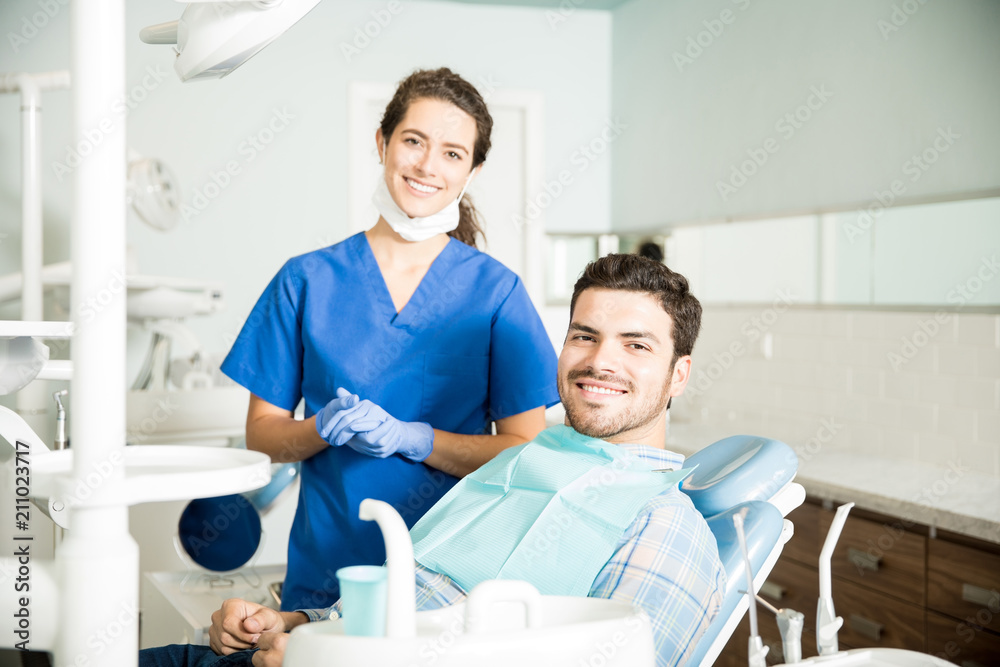 Portrait Of Smiling Dentist And Mid Adult Man In Clinic Portrait Of Smiling Dentist And Mid Adult Man In Clinic