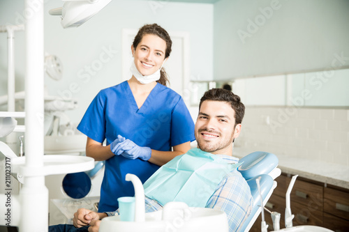 Portrait Of Smiling Dentist And Mid Adult Man In Clinic