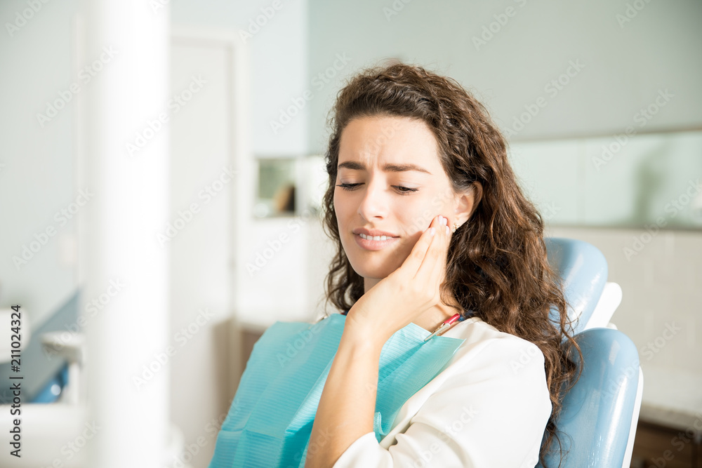 Young Woman Suffering From Toothache In Dental Clinic Young Woman Suffering From Toothache In Dental Clinic