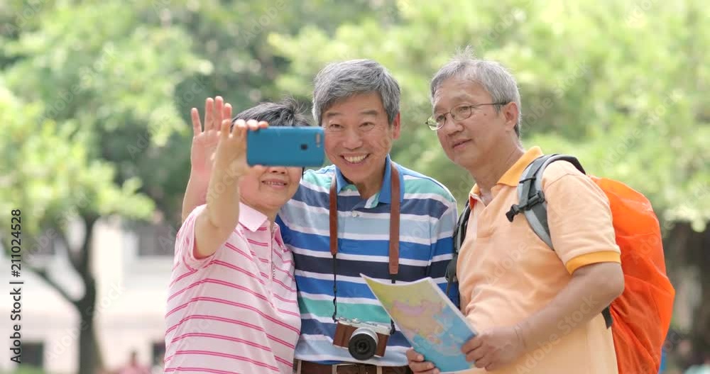 Senior friends go travel together and taking selfie by mobile phone Senior friends go travel together and taking selfie by mobile phone
