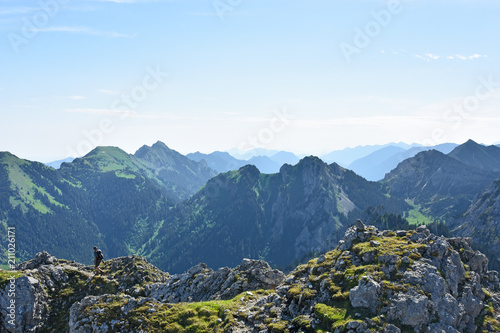 Hiker at the summit of Geiselstein mountain under blue sky at a beautiful day in spring. Ammergau Alps, Bavaria, Germany photo