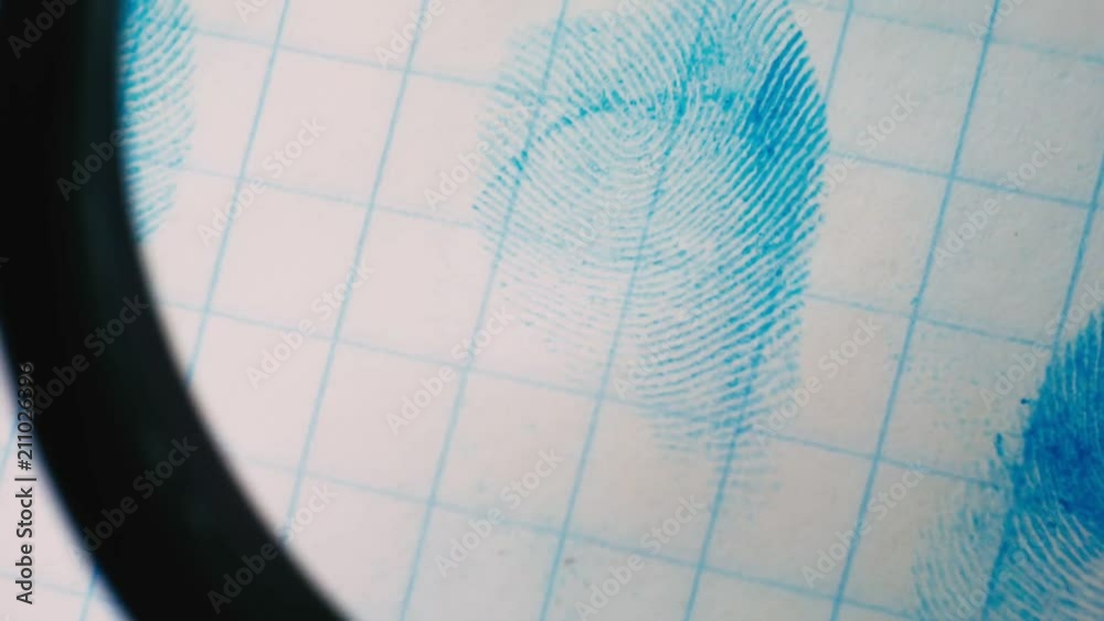 fingerprint on a sheet of paper is seen through a magnifying glass.close-up fingerprint on a sheet of paper is seen through a magnifying glass.close-up