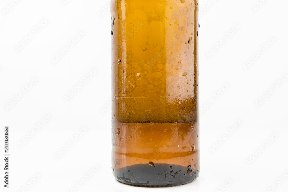 Ice Cold Wet Condensated Lager Beer Bottle With Beer And Foam Inside Isolated On White Background Ice Cold Wet Condensated Lager Beer Bottle With Beer And Foam Inside Isolated On White Background
