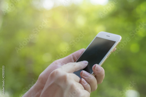 Man using his Mobile Phone outdoor, close up