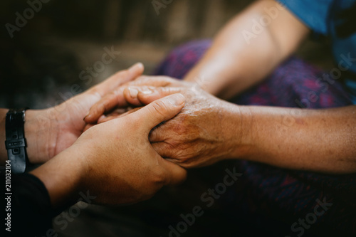 Young hands holding old hands and pray together,Pray for the elderly concept.