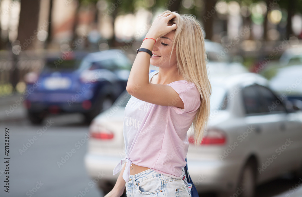 Beautiful woman with long legs walking around City street wearing jeans shorts.