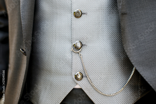 Dettaglio abito da sposo di gilet con catena  legata ad orologio dentro tasca photo