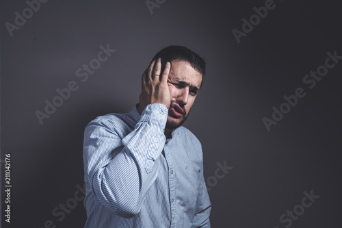 man with a toothache puts his hand