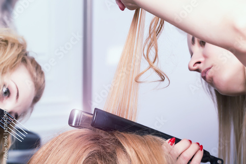 A hairdresser making a haircut for a blonde female client