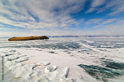Transparent ice with cracks on Lake Baikal near Shamanka cliff. Winter Baikal lake, Russia. photo