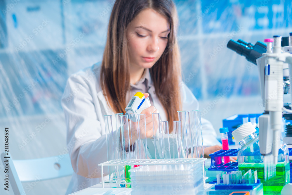 student woman with multi pipette and other PCR items in microbiological / genetic laboratory student woman with multi pipette and other PCR items in microbiological / genetic laboratory