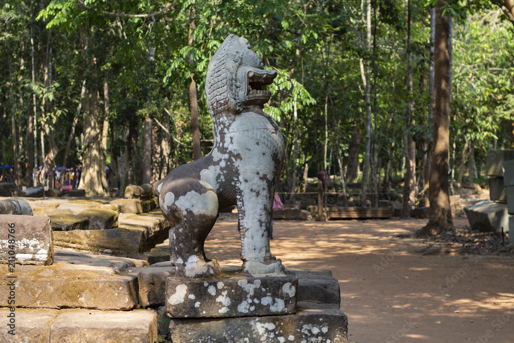Mossy stone lion statue, Angkor Wat temple complex, Cambodia. Spiritual protector Barong. Ancient temple in Siem Reap.