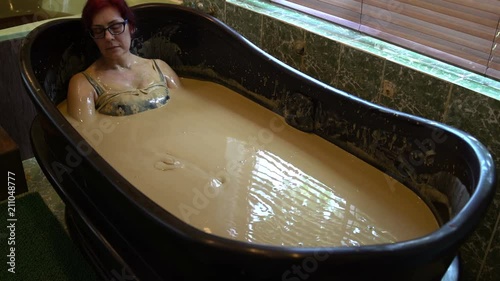Woman relaxes in the mud bath
