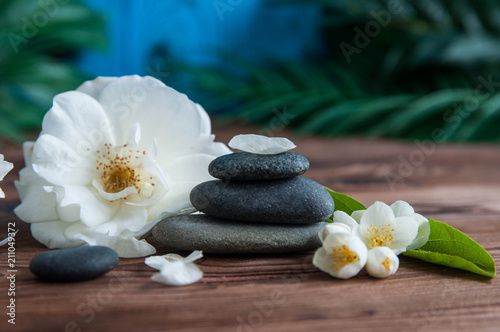 Pyramids of gray zen stones with beautiful fresh white flowers. Concept of harmony  balance and meditation  spa  massage  relax