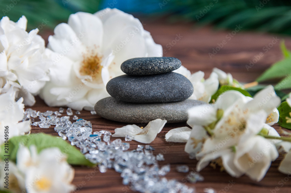 Pyramids of gray zen stones with beautiful fresh white flowers. Concept of harmony, balance and meditation, spa, massage, relax Pyramids of gray zen stones with beautiful fresh white flowers. Concept of harmony, balance and meditation, spa, massage, relax