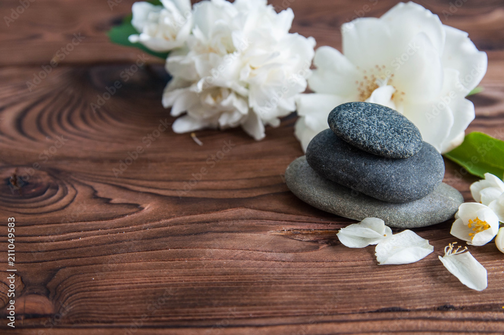 Pyramids of gray zen stones with beautiful fresh white flowers. Concept of harmony, balance and meditation, spa, massage, relax Pyramids of gray zen stones with beautiful fresh white flowers. Concept of harmony, balance and meditation, spa, massage, relax