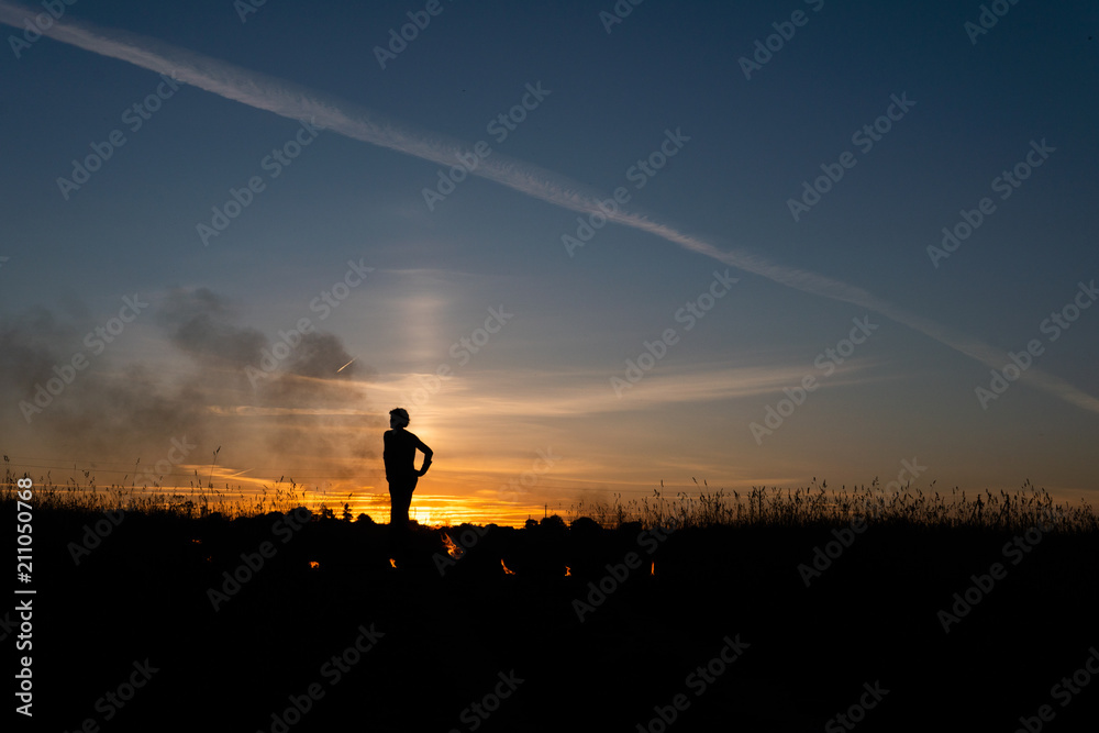 A man with a torch at sunset. Fire show and a lot of the bright sparks in the night A man with a torch at sunset. Fire show and a lot of the bright sparks in the night