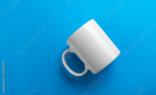 Obraz na plátně Flipped white mug on blue background