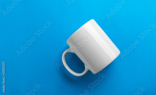 Flipped white mug on blue background