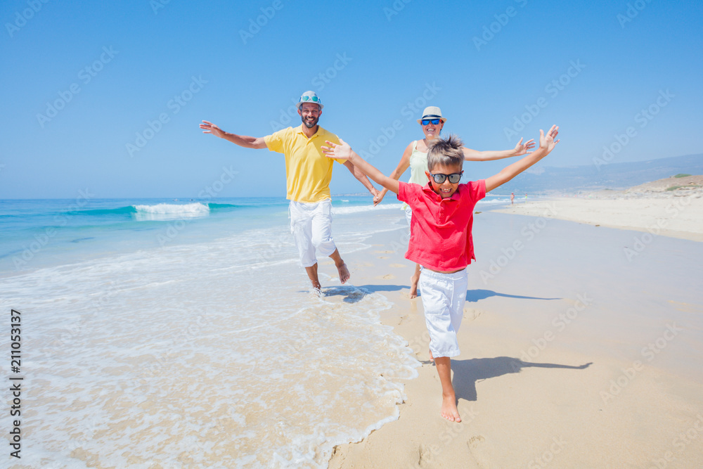 Family having fun and running on a sandy beach Family having fun and running on a sandy beach