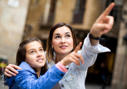 Mother and daughter pointing at sight during
